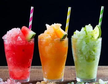 Tres cócteles granizados de colores con pitillo