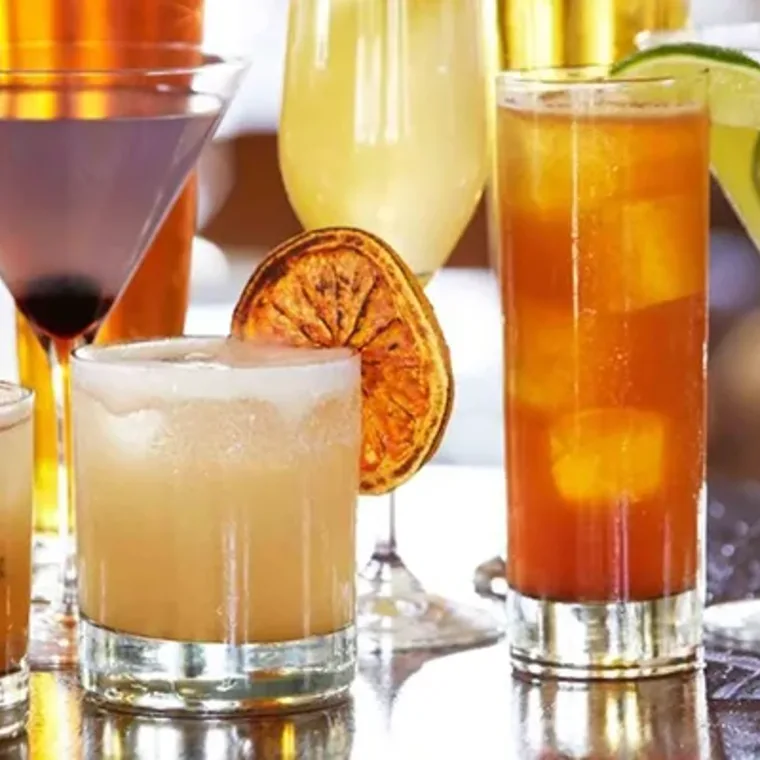 Cócteles de autor con naranja deshidratada servidos en la barra